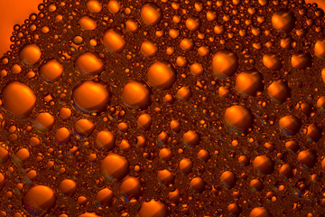 orange and yellow liquid background. foam texture. close up
