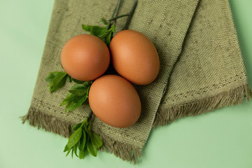 three eggs on napkins and decor of twigs with leaves