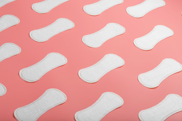 Sanitary pad on a pink background in the form of a diagonal pattern. Textured background over the entire screen.