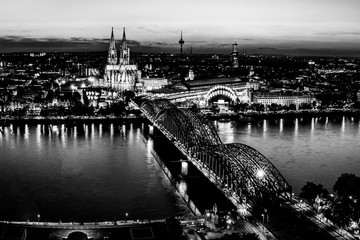 Cologne, Germany: Beautiful panoramic aerial night landscape of the gothic catholic Cologne cathedral, Hohenzollern Bridge and the River Rhine at sunset, golden hour and blue hour.