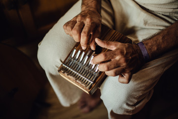 Close up photo of hands of an Indian musician playing kalimba