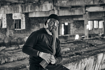 Guy in an abandoned factory, wearing mask for protection from corona virus covid-19