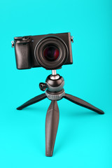 Professional camera on a tripod, on a blue background. Record videos and photos for your blog or report.