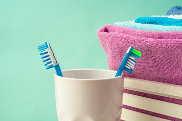Turquoise bathroom. Colored a cotton toweles, toothbrushes in a glass on turquoise backdrop....