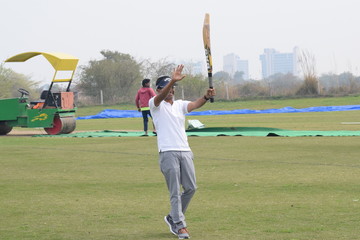 Full length of cricketer playing on field during sunny day, Cricketer on the field in action,...