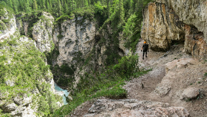 Going through a difficult trail in the full inventory located in the gorge. Dolomites in the Alps.