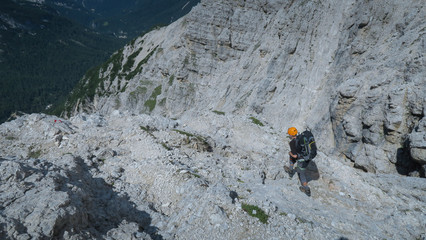 Tourist with equipment on the via ferrata trail in the Dolomites