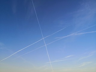 Vapor trails in blue sky in the evening, symbol of air travel with  copy space
