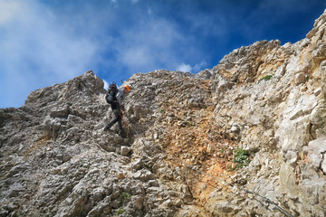 Tourist with equipment on a mountain trail in the Alps