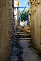 Fototapeta na wymiar Narrow ancient pedestrian street with stairways in old town. Central Asia travel view
