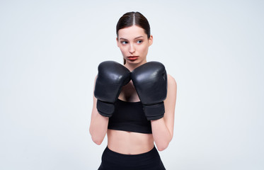 The girl on a white background goes in for sports, boxing.