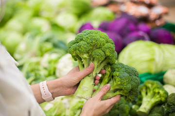 Woman are selecting fresh broccoli in grocery farm- market