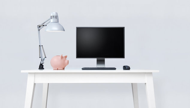 Clean white table with piggy bank and desktop computer.