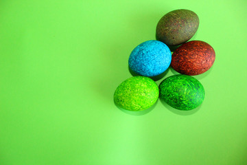 Fototapeta na wymiar Lots of colored eggs on a green background.