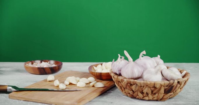 Male hand puts the peeled garlic cloves on a cutting Board.
