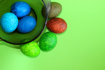 Lots of colored eggs on a green background.