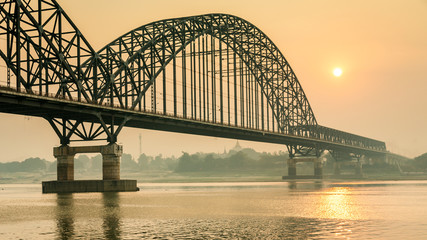 Naklejka premium Sunrise at Sagaing bridge spanning over the Irrawaddy river