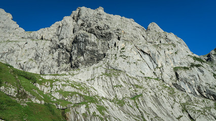 Rocky mountain slope covered with grass in the Alps