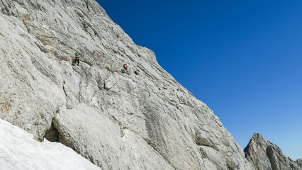 View of the glacier in the alps and tourists marching on it