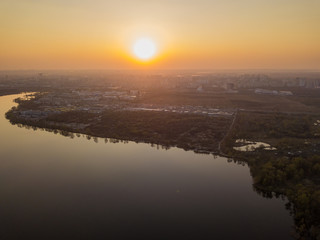 Sunset over the lake in the city. Aerial drone view.