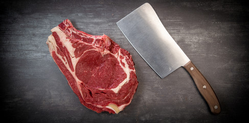 Raw T Bone steak on wooden board prepared to Grill 