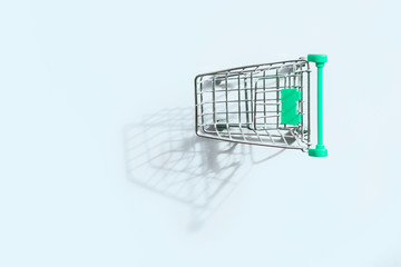 Shopping cart on gray background with copy space, top view. Concept of shopping, sales, business,...