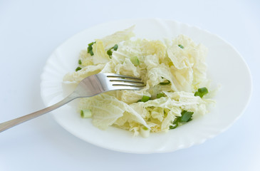 Healthy garden salad on a white plate with a silver fork. Isolated on white background