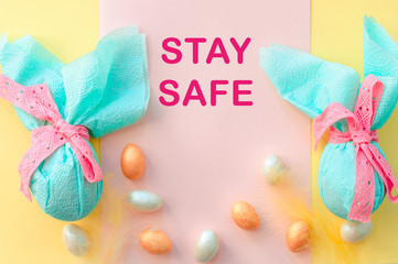 Egg gift in green paper packaging and with pink ribbon Easter Bunny wrap idea. Minimal. Flat lay, Copy space, Coronavirus covid-19 pandemic quarantine self isolation, 2019-nCoV