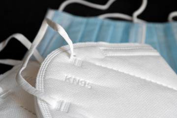 white KN95 or N95 mask with antiviral medical mask for protection against coronavirus on black...