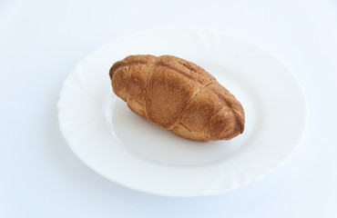Fresh croissant on a white plate. Isolated on white background. Close up