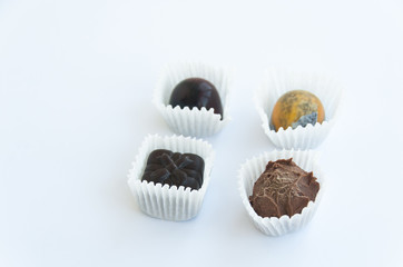 Four handmade chocolate sweets isolated on a white background. Close up