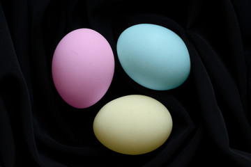 Multi-colored Easter eggs on black silk fabric.