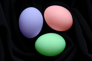 Multi-colored Easter eggs on black silk fabric.