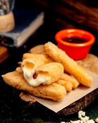 cheese sticks in batter on a wooden hemp