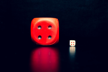 Big red dice next to a small white dice