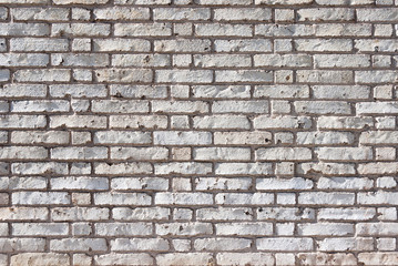 Full frame textured background of weathered brick wall with chipped and peeling white paint