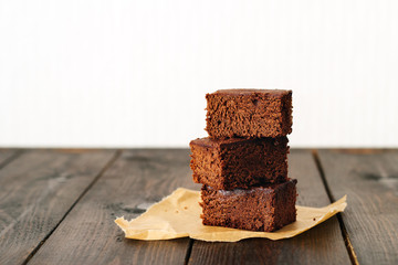 Brownie, chocolate cake on a dark rustic wooden table