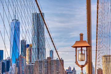 Fototapeta na wymiar Brooklyn Bridge lamp and cables with a Manhattan in the background in New York