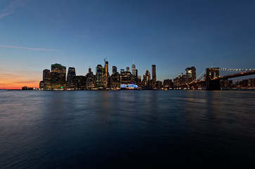 Fototapeta na wymiar Long exposure wide panorama of Manhattan downtown at sunset from the Brooklyn Bridge Park.