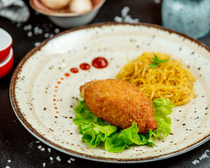 chicken kiev with salad and spaghetti in a plate