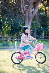 Obraz premium 春の公園で自転車を乗って遊んでいる可愛い子供