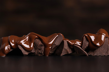 melted chocolate covers the pieces. delicious dessert on black table