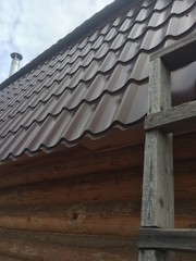 a staircase leaning against the outer wall of the village house and part of the roof with a chimney