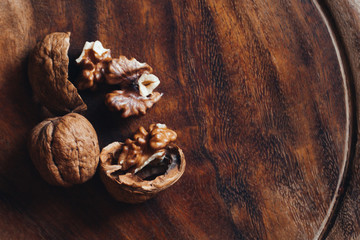 Top view of walnuts on rustic wooden plate. Concept: dried fruit, work in the kitchen, natural food