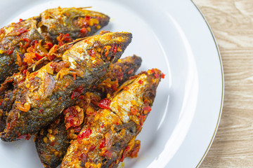ikan balado in white plate. indonesian food made from fried fish cooked with red chili. has a savory and spicy taste and has good nutritional content for the body