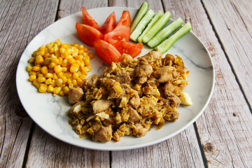 Chicken with o scramble, fresh cucumbers and tomatoes and corn