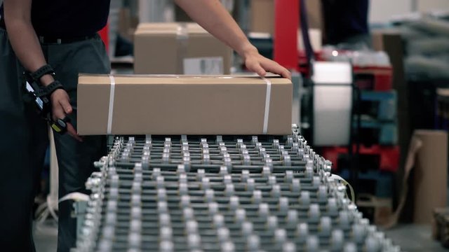 Parcels are scanned on the packaging line in a warehouse. Parcels wait on the conveyor to be shipped. Automation of online shipping logistics