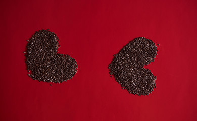 two hearts made of chia seeds on a red background