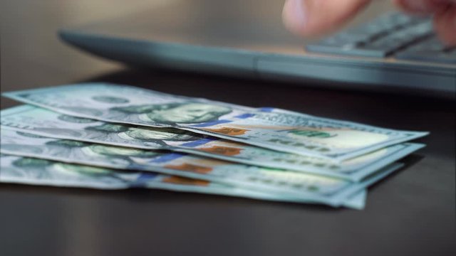 Crop employer paying salary in American dollar bills