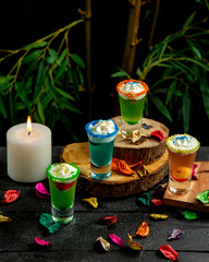 colored cocktails with whipped cream and pieces of fruit and berries